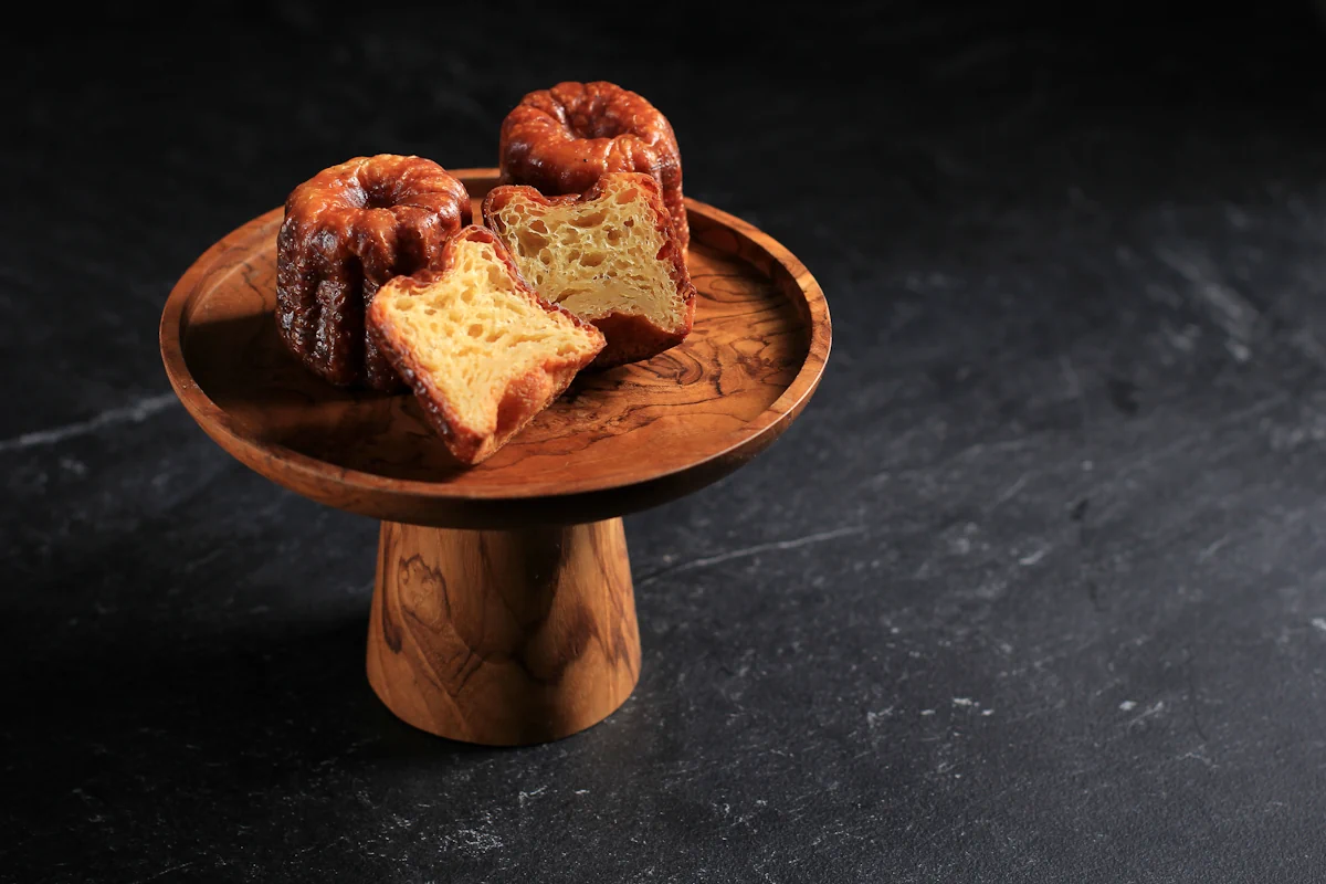 Des cannelés présentées sur un plateau en bois
