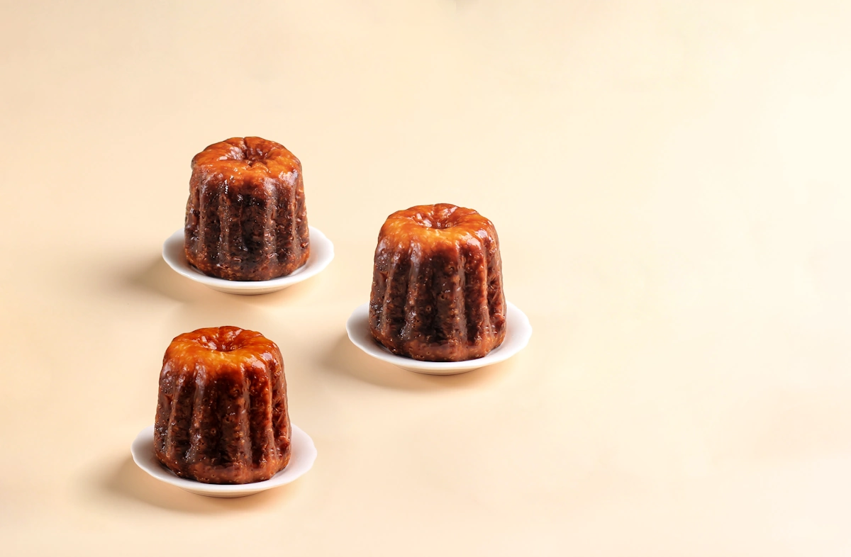 3 cannelés posées sur une surface rosée