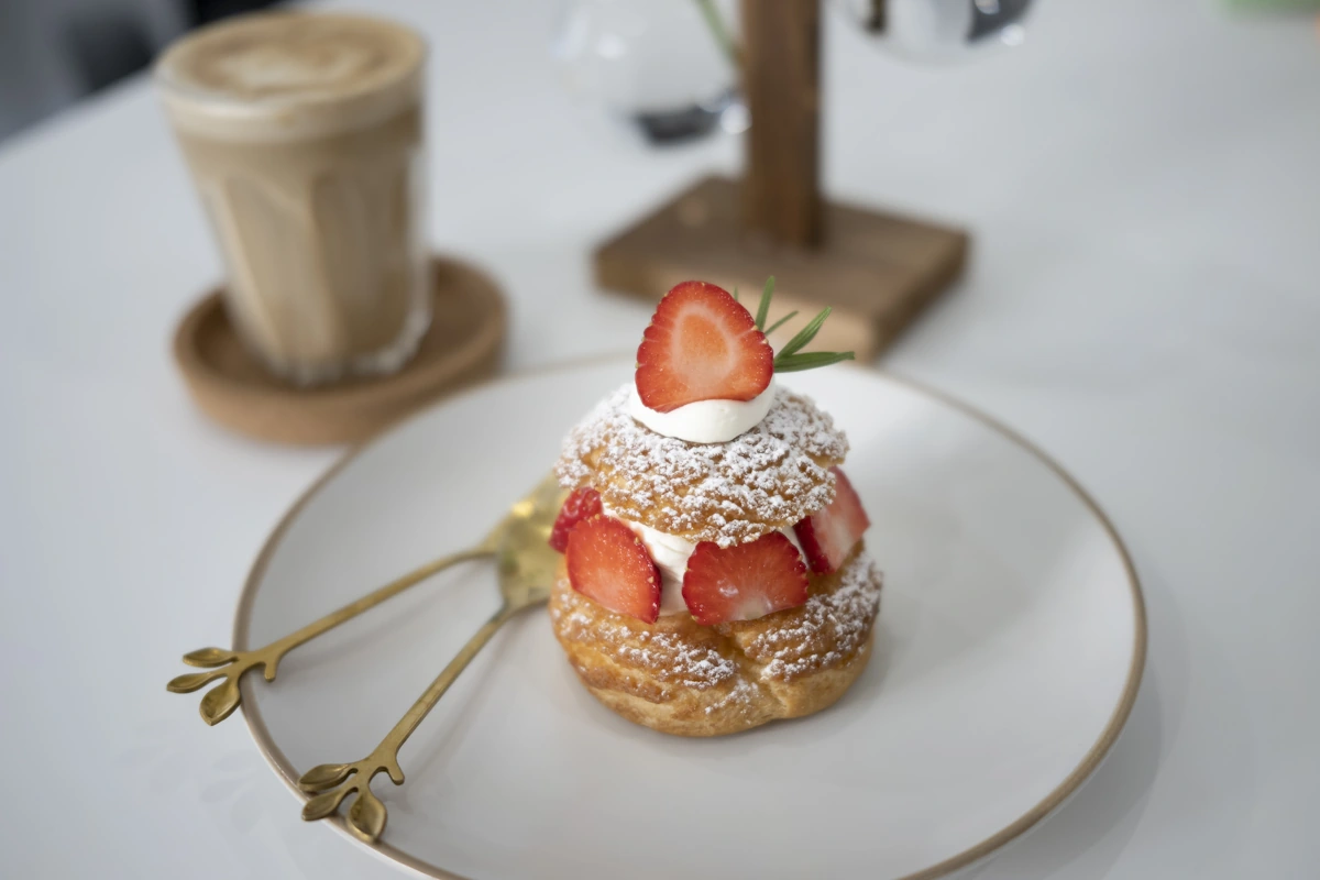 Une assiette avec un chou à la crème et des fraises