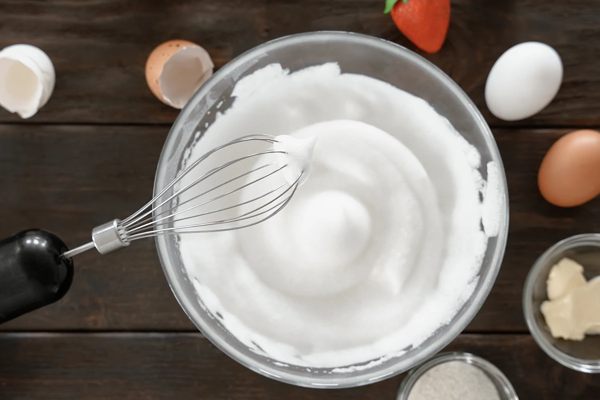 Une crème chantilly dans un bol avec un fouet