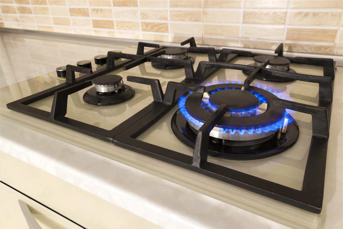 Une plaque de cuisson à 4 feux avec un feu allumé