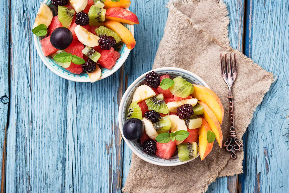 Deux assiettes de salade de fruits posé sur une surface en bois