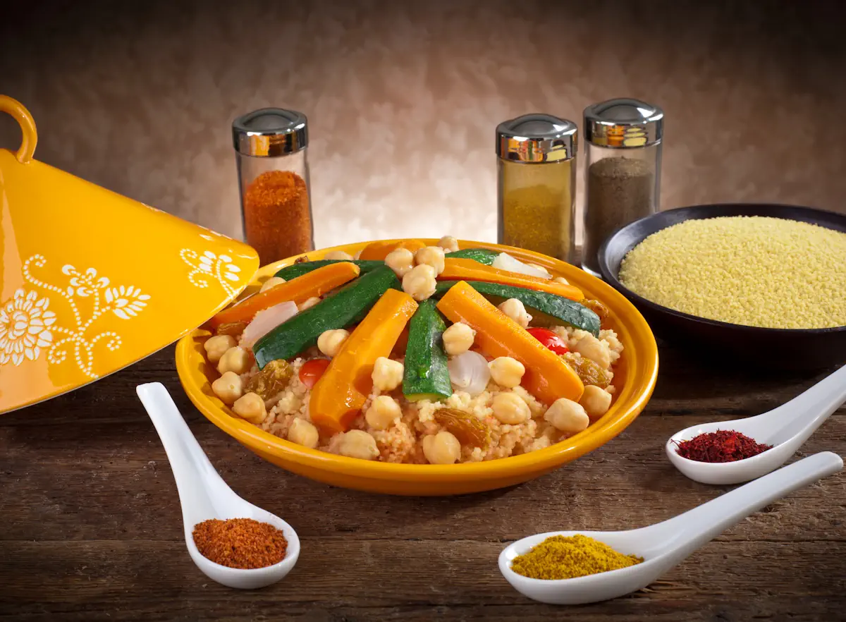 Un plat de tajine traditionnel posé sur la table à côté de quelques épices