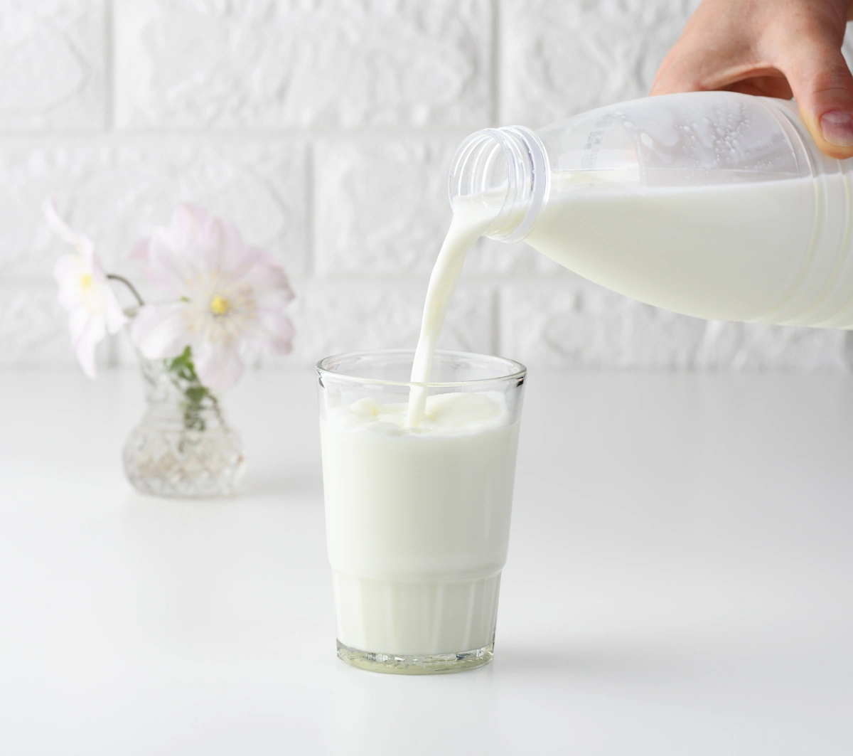 mesure précise de 100 ml de lait dans un verre en cuisine