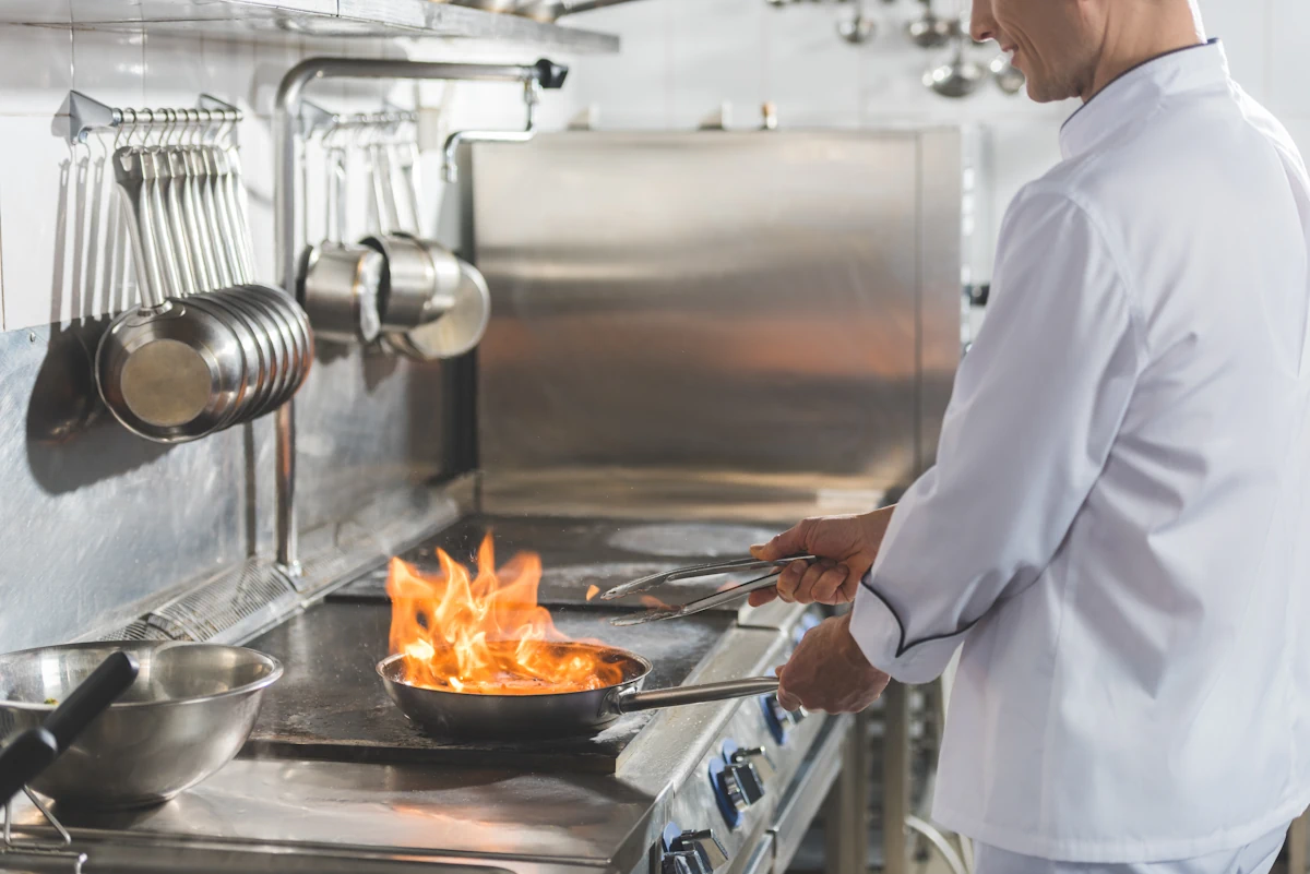 un cuisinier qui utilise une plaque avec une poêle