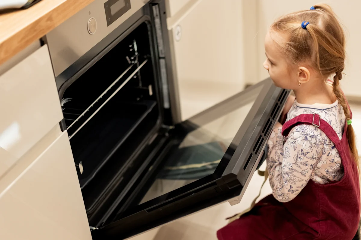 Une petite fille qui regarde à l'intérieur du four