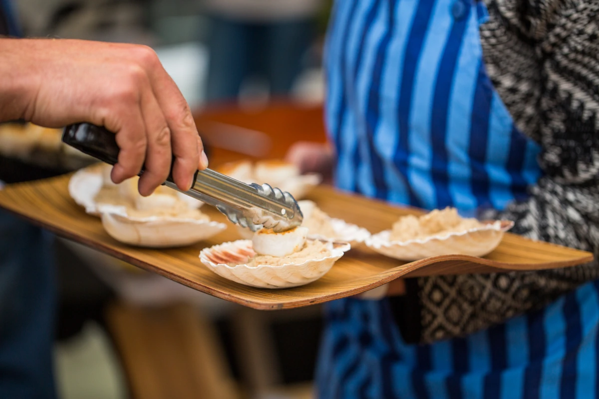 Ouverture d'une coquille Saint-Jacques fraîche avec un couteau de cuisine