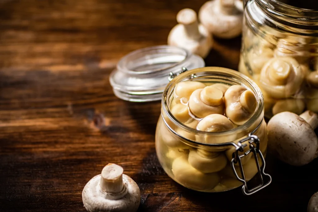 Des champignons dans un bocal posé sur la table
