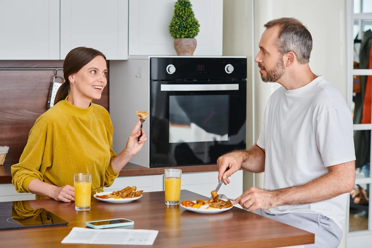 Un couple qui mange ensemble une assiette de poulet avec des sauces