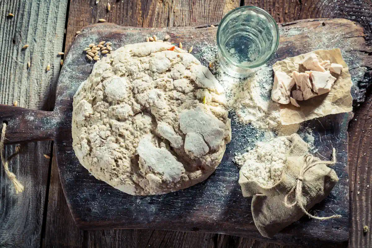 Une préparation de pâte sur une table avec de l'eau dans un verre à côté