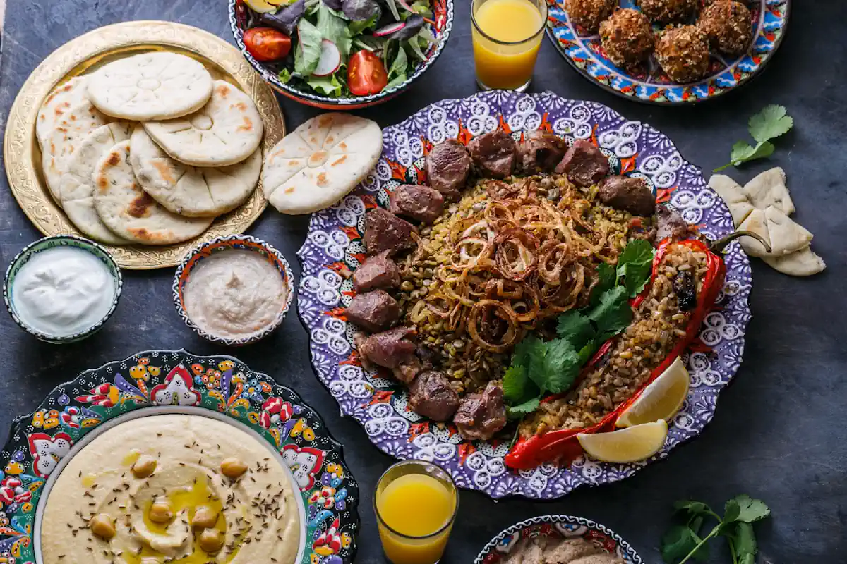 Une assiette de mloukhia libanaise posé à côté de pains et d'une salade sur une table