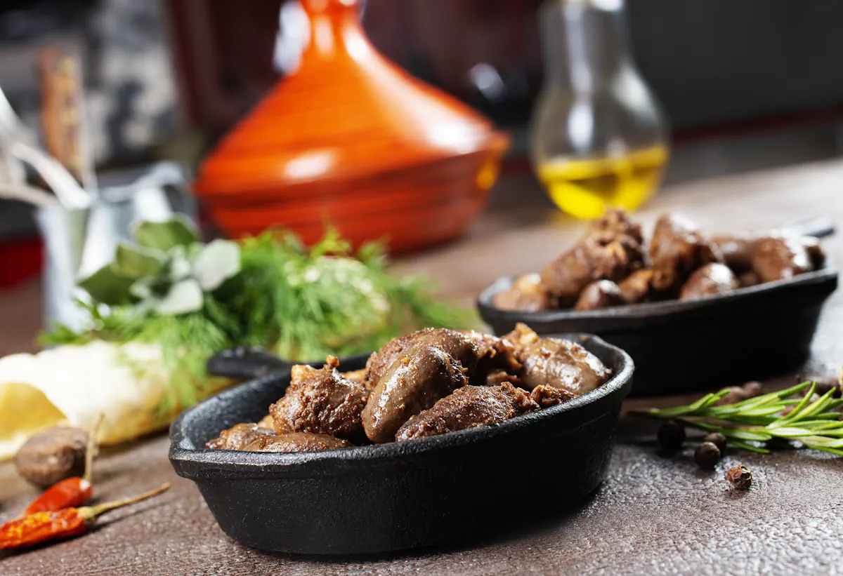 Une assiette de foie d'agneau marocaine posée sur une table à côté de salades
