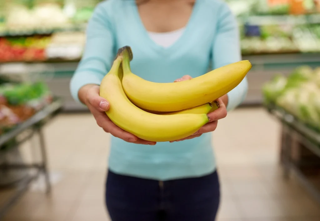 Une femme qui tend des bananes