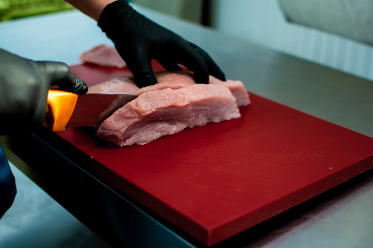 Une personne qui coupe un morceau de viande