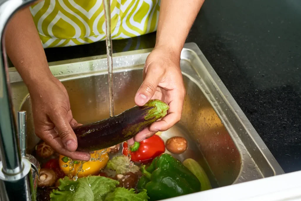 Une personne qui lave des légumes