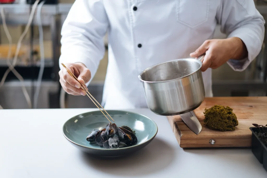 Un chef qui prépare une assiette de moules