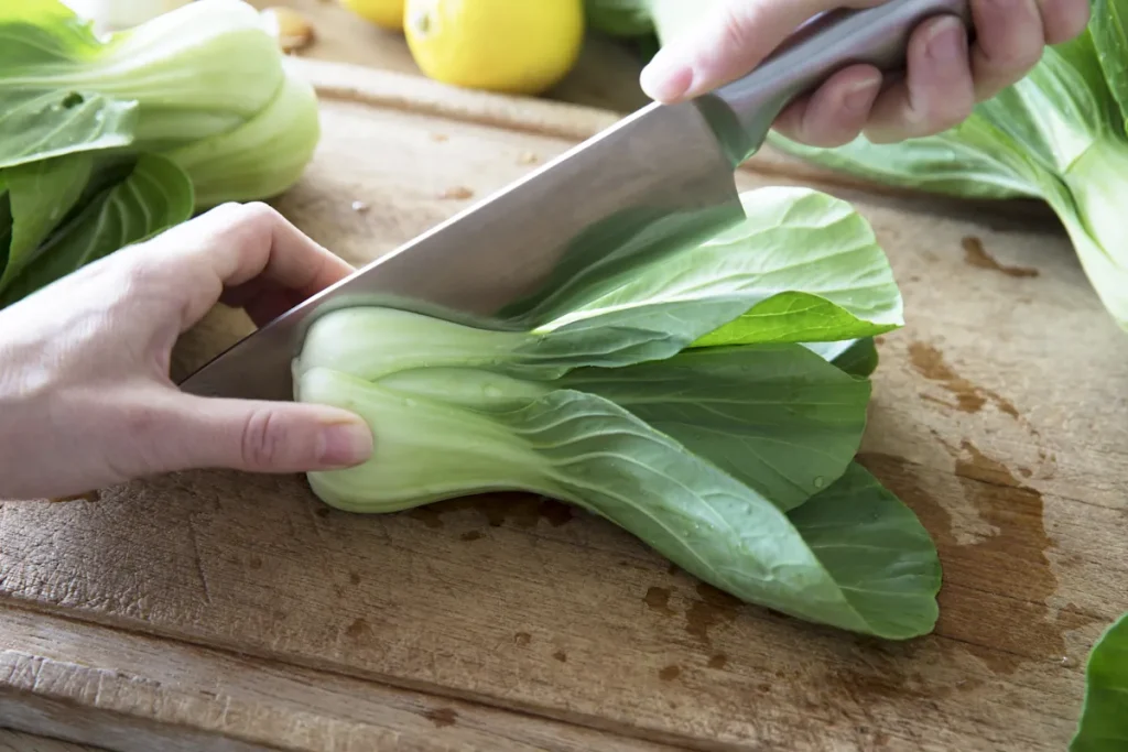 Une personne qui prépare du pak choi