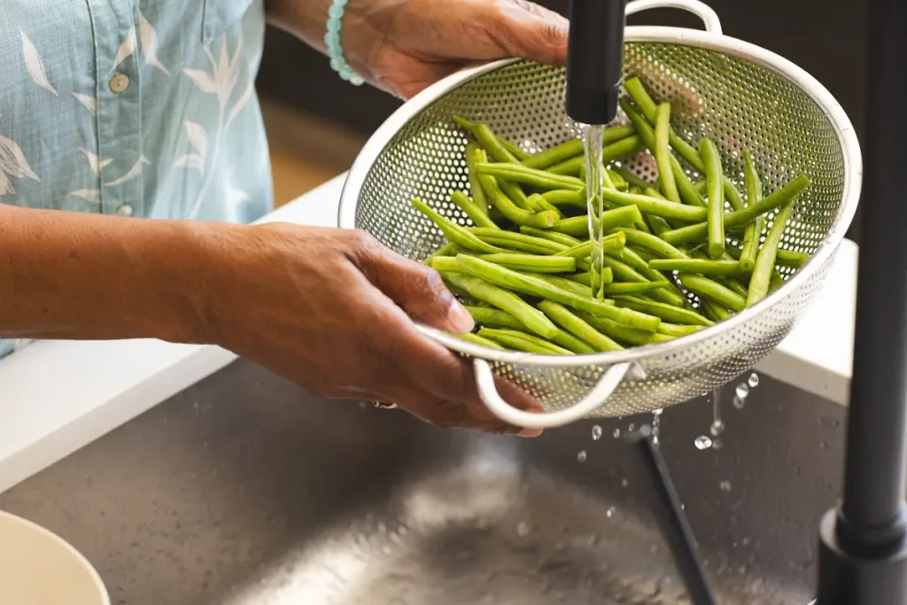 Une personne qui lave des haricots verts
