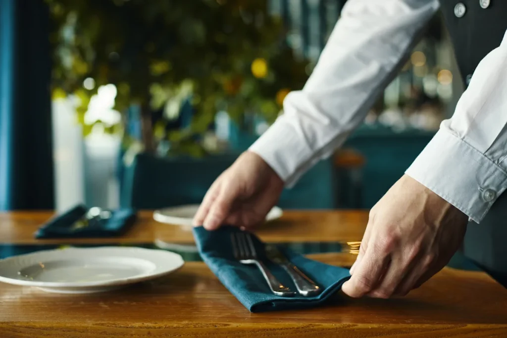 Un homme qui installe une serviette de table