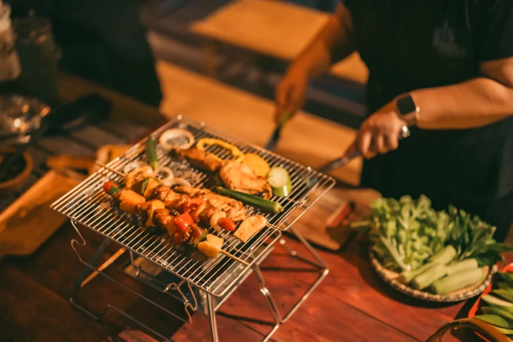 Une personne qui cuir des légumes à la barbecue