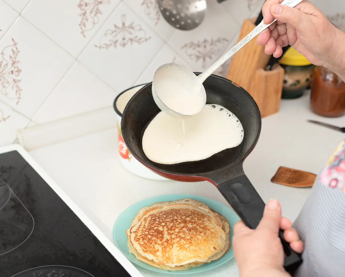 Une personne qui cuit des crêpes