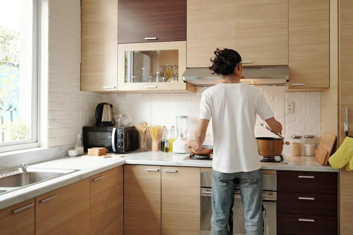 un homme qui cuisine dans une cuisine en L