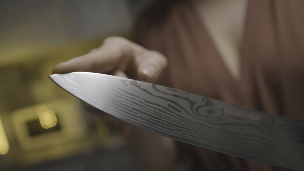 Une femme qui vérifie un couteau de chef