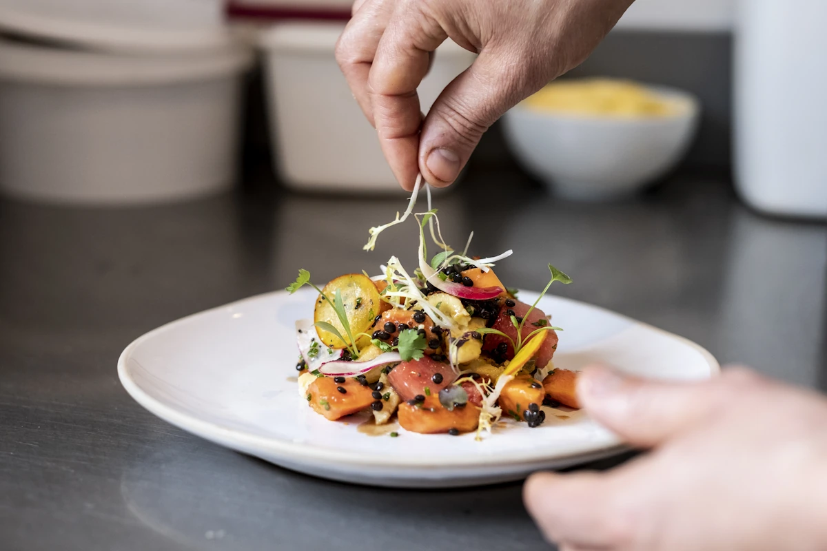 Une personne qui dresse une assiette avec de la hauteur