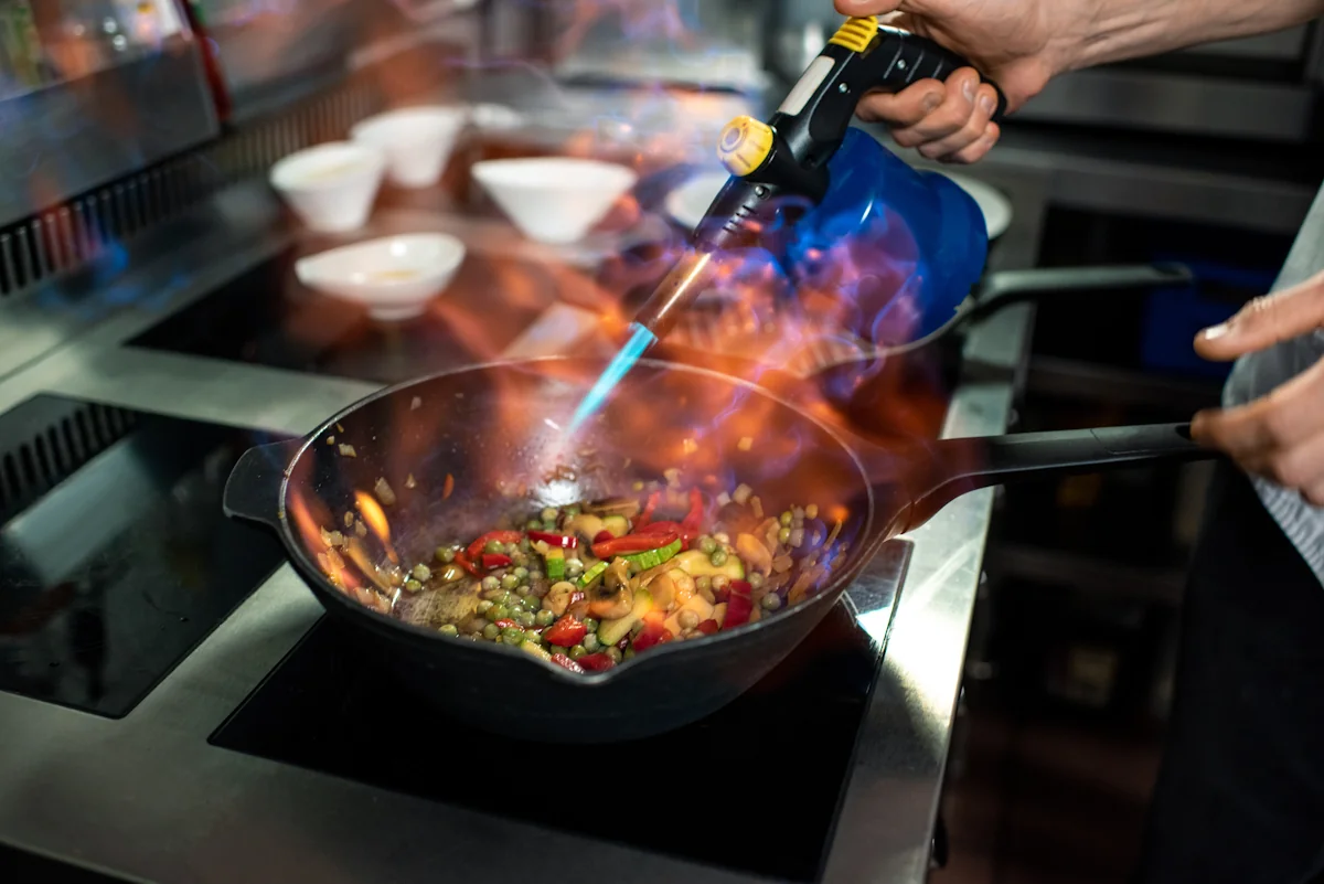 Une personne qui flambe un plat