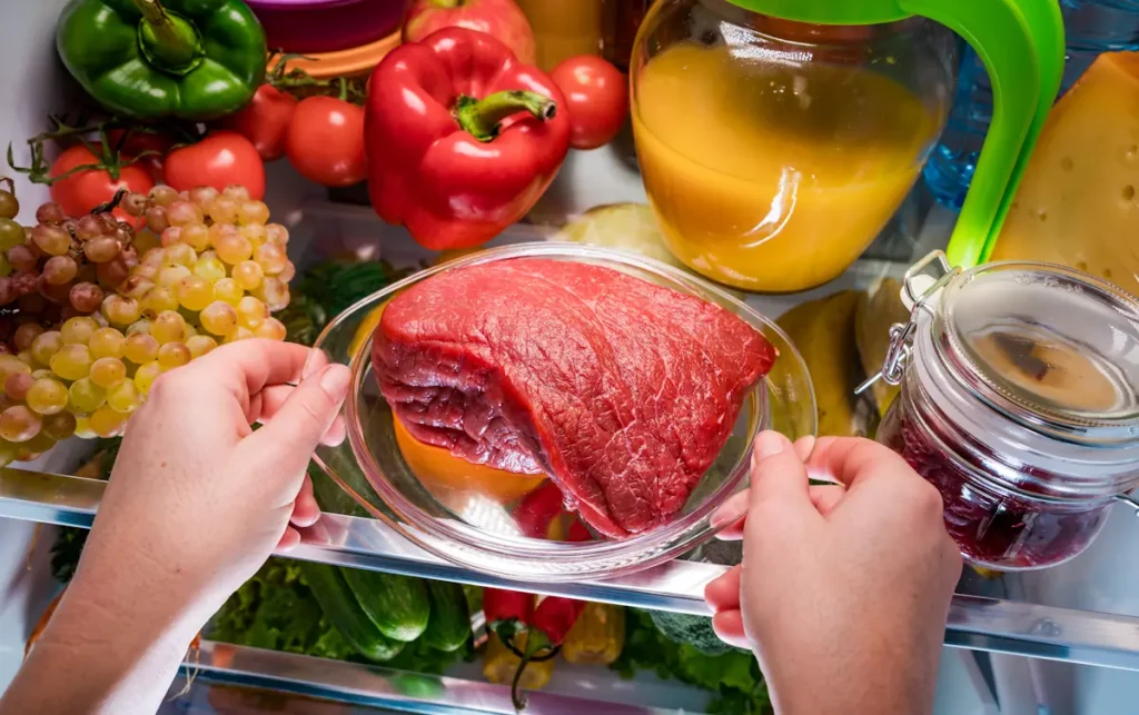 Une personne qui fait maturer viande frigo