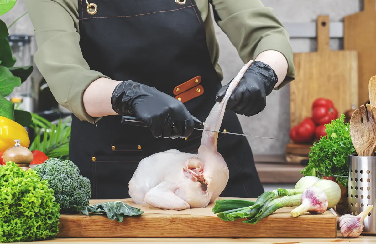 Un homme qui désosse les ailes d'un poulet