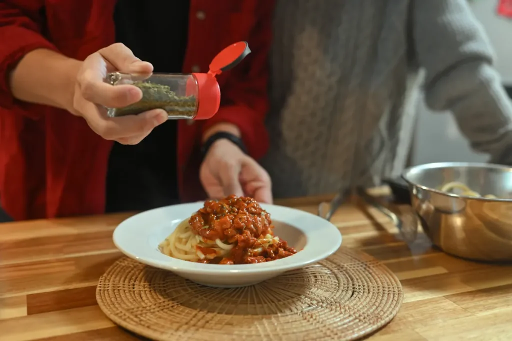 Une personne qui ajoute des épices dans un plat