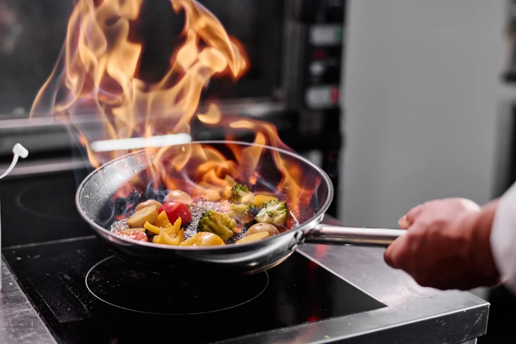 Une personne qui flambe un plat avec du cognac