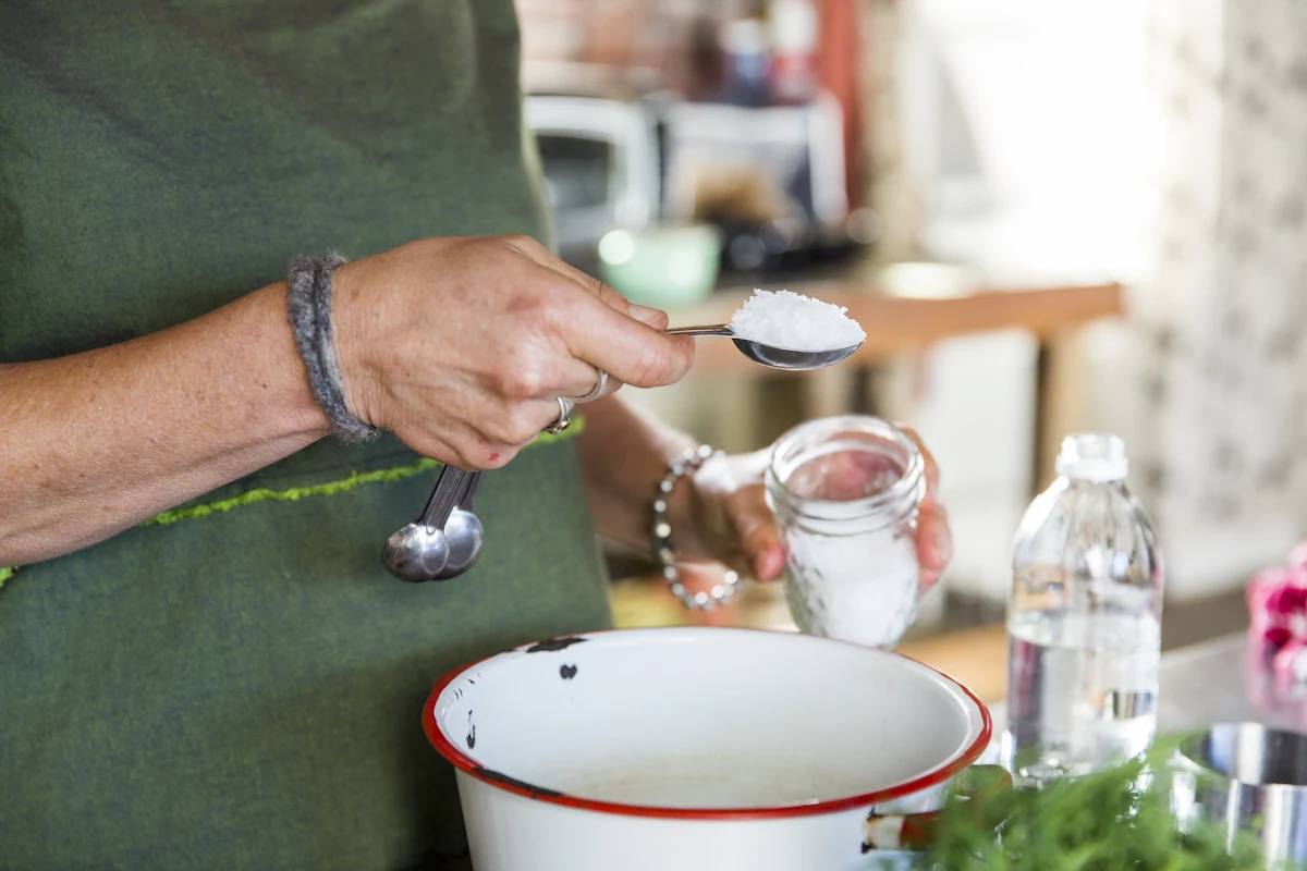 Une personne qui ajoute du fleur de sel dans un plat