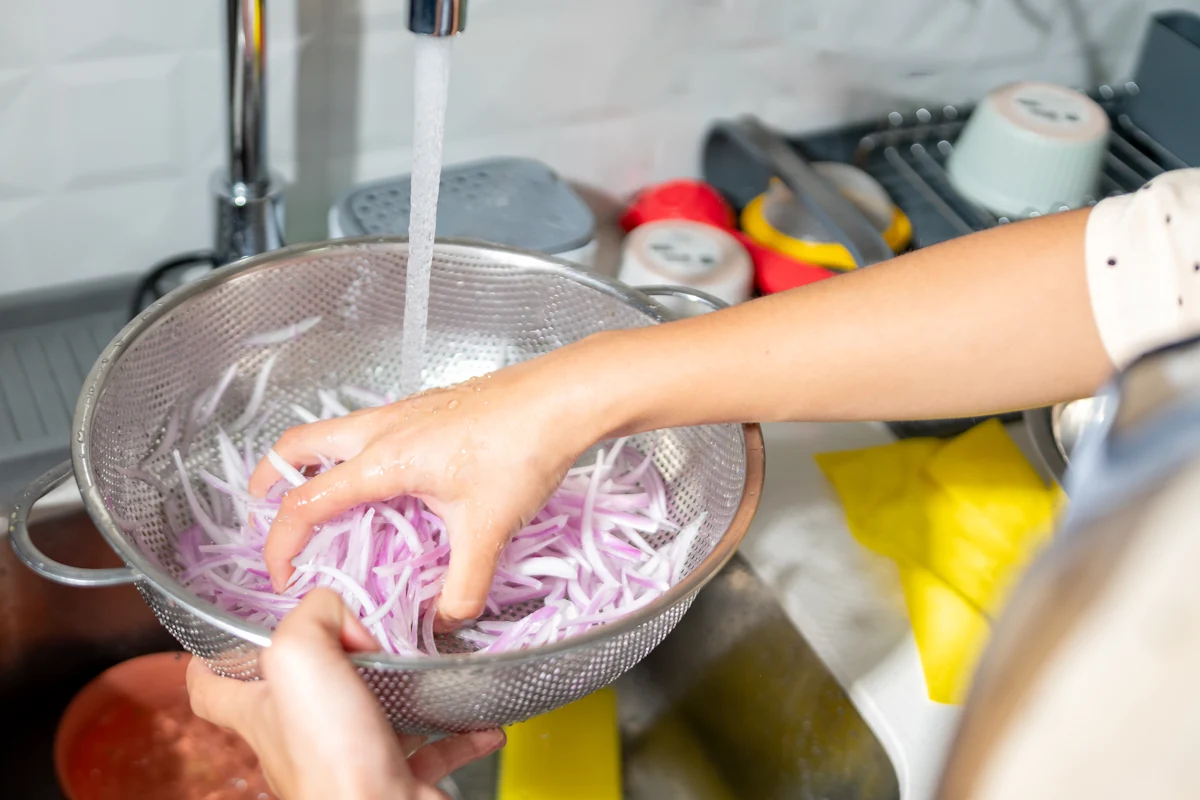 Une personne qui lave des oignons émincés