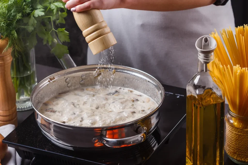 Une personne qui sale une sauce