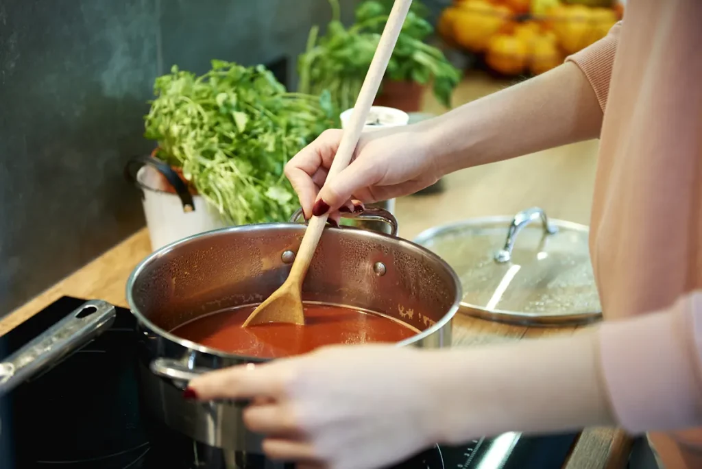 Une personne qui prépare une sauce tomate